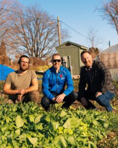 Ben Wilcox, left, director of farm operations at Urban Roots, Jordan Moat, regional manager at Libro Credit Union, and Colin Lewis, director of strategic alliances at Equitable Bank, with a patch of arugula at Urban Roots in London on Thursday, Nov. 7, 2024